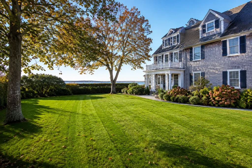 Healthy Martha’s Vineyard estate lawn in early fall with coastal home and autumn foliage